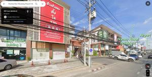 バンコクにあるSleepy and Homey Don Mueang Airport Hostelの車が建物の前に停まった街道