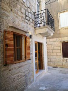 a building with a balcony and a door and window at Casa Pandula in Komiža