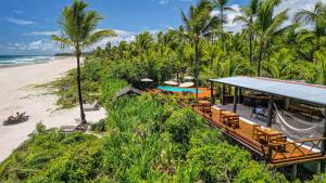 ein Resort am Strand mit Palmen und dem Meer in der Unterkunft Aldeia da Mata Ecolodge in Serra Grande