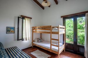 a bedroom with bunk beds in a room with a window at The Gift Sani Villa in Sani Beach