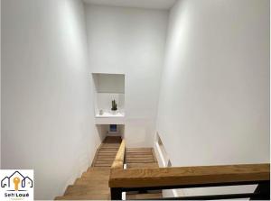 eine Treppe mit einem Waschbecken in einer weißen Wand in der Unterkunft Evasion in Saint-Brieuc