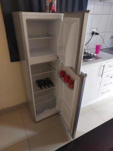 einen Kühlschrank mit offener Tür in der Küche in der Unterkunft BERG STREET APARTMENTS in Johannesburg