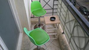 Duas cadeiras verdes e um banco numa varanda em Ruby Star Hostel Loft Bed 21 em Dubai