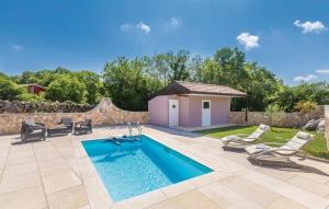 a swimming pool with lounge chairs and a house at Villa Patrick in Gostinjac