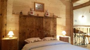 a bedroom with a bed in a wooden wall at La Fée Verte in Arc-sous-Cicon +69 photos