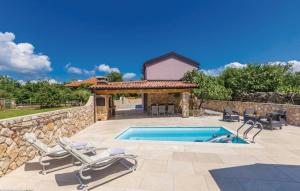 a swimming pool with lounge chairs next to a stone wall at Villa Patrick in Gostinjac