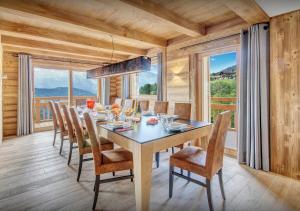 a dining room with a table and chairs and a large window at Chalet Nougat - Les Congères in Manigod