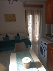 uma sala de estar com um sofá e uma máquina de lavar roupa em Snuggery Elegant Apartment em Agios Nikolaos