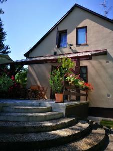 una casa con escaleras y flores delante en 3 Tó Sziki Szálló, en Szeged