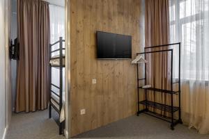a room with a bunk bed and a television on a wall at Eden 3 & Eden 4 in Predeal