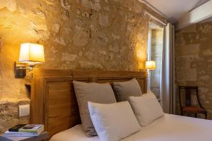 ピュイスガンにあるChâteau Fleur de Roques - Puisseguin Saint Emilionのベッドルーム1室(白い枕2つ付きのベッド1台付)