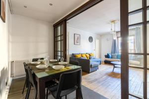 a dining room and living room with a table and chairs at Appartement Quartier la Madeleine Free Netflix in Paris