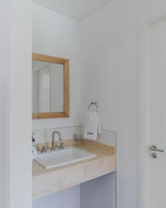 a bathroom with a sink and a mirror at Chadel Management Cafayate in Cafayate