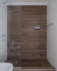 a bathroom with a shower with a wooden wall at Chadel Management Cafayate in Cafayate