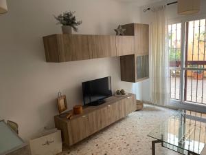 Una sala de estar con un televisor de pantalla plana en una pared. en Luchana 15, en Málaga