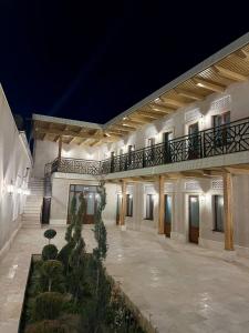 a large building with a balcony and a courtyard at Antique Hotel Rizvan in Bukhara