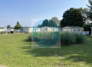 a window with a sign in a field of grass at 3 Bedroom Caravan for Hire Butlins Minehead in Minehead