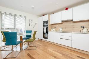 a kitchen with white cabinets and a table and chairs at Argyle Rigg - No 16C in St. Andrews