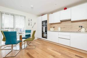 a kitchen with white cabinets and a table and chairs at Argyle Rigg * Deluxe Central Townhouse * Balcony in St Andrews