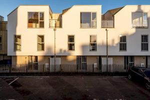 a white building with a fence in front of it at Argyle Rigg * Deluxe Central Townhouse * Balcony in St Andrews