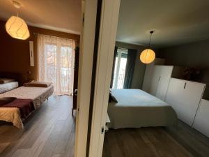 1 dormitorio con 2 camas, 2 ventanas y 2 lámparas en La Bollicina Boutique Apartment and Spa, en Verbania