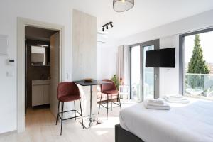 a bedroom with a bed and a table and chairs at Velvet Luxury Studios in the City Center by BiNoBi! in Thessaloniki