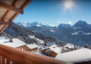 a view from a balcony of a ski resort with snow covered mountains at Chalet Chamallow - Les Congères in Manigod