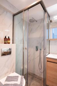 a shower with a glass door in a bathroom at Velvet Luxury Studios in the City Center by BiNoBi! in Thessaloniki