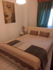 um quarto com uma cama grande e cortinas azuis em Snuggery Elegant Apartment em Agios Nikolaos