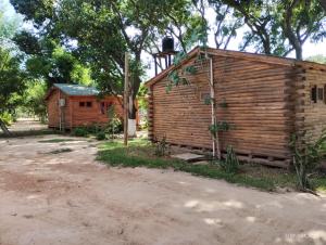 a wooden building sitting next to a dirt road at Camping Caperucita Roja in Clorinda