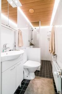 a white bathroom with a sink and a toilet at Studio apartment in lake views in Tampere