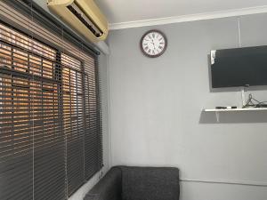 a room with a window with a clock on the wall at Ashridge Guesthouse & Safaris in Hazyview
