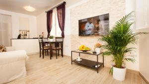 a living room with a tv on a brick wall at Apartments Villa Bianca in Rovinj
