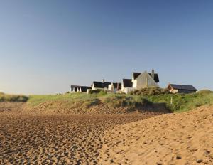 a house sitting on top of a sandy beach at Sandy Paws Anderby Creek - Dog Friendly in Skegness
