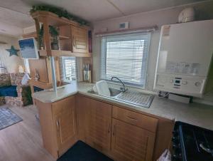 a kitchen with a sink and a counter top at Sandy Paws Anderby Creek - Dog Friendly in Skegness