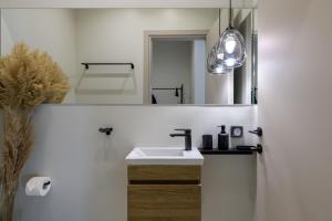 a bathroom with a sink and a mirror at Penthouse W/ View & Plunge Pool in Athens
