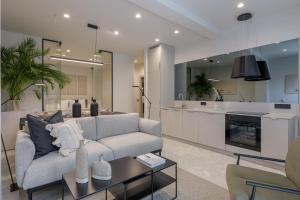 a living room with a couch and a kitchen at Penthouse W/ View & Plunge Pool in Athens