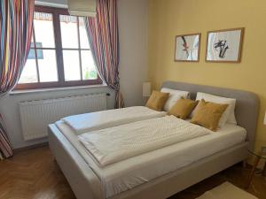 a large bed in a bedroom with a window at IV Gemütliche Ferienwohnung in Pool-Position in Sankt Michael ob Bleiburg