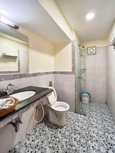 a bathroom with a toilet and a sink and a mirror at 6 BedRooms Nr Majorda Beach with pool in Majorda