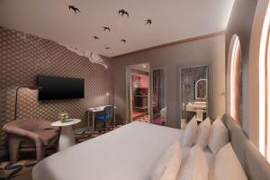 a bedroom with a large white bed with birds on the wall at NH Collection Roma Vittorio Veneto in Rome