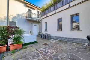 a courtyard of a white building with a table and plants at Extra Comfort - Casa Vicino a Milano e Linate in Zelo Buon Persico