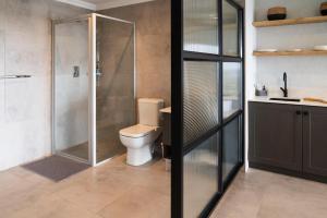 a bathroom with a toilet and a glass shower at Sunrise on Gazelle in Jeffreys Bay