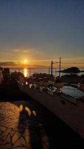 a sunset over a city with the sun setting over the ocean at Hotel Lachea in Acitrezza
