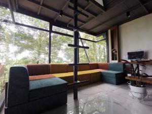 a living room with a couch and a large window at Wildrootstay 3 bed cottage in Pinangode