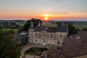 an old castle with the sunset in the background at Château Fleur de Roques - Puisseguin Saint Emilion in Puisseguin
