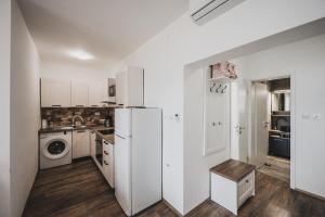 una cucina con mobili bianchi e un frigorifero di Villa Sabrina a Klimno Altre 17 foto