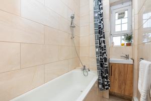 a bathroom with a tub and a sink at Peaceful 1BR in Vibrant South Bank, 7min Borough in London