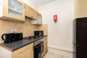 a small kitchen with a stove and a refrigerator at Peaceful 1BR in Vibrant South Bank, 7min Borough in London