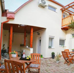 eine Terrasse mit Stühlen und einem Tisch vor einem Haus in der Unterkunft Várfal apartman in Eger