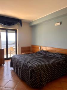 1 dormitorio con cama y vistas al océano en Hotel Lachea, en Aci Trezza